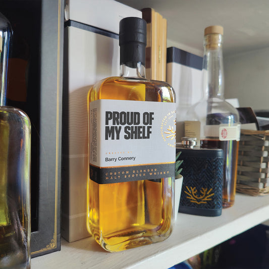 Personalised 500ml whisky labelled "Proud of my shelf" sitting on a shelf